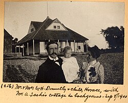 Mr. and Mrs. W. H. Donnelly and their child, Horace, in front of Arthur Taché's cottage, Britannia, Ontario