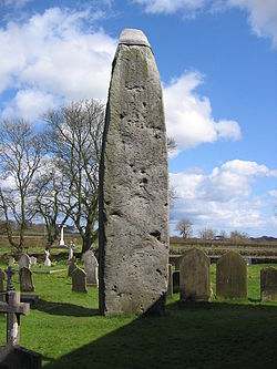 The Rudston Monolith, almost 26ft high, close to Rudston Parish Church of all Saints